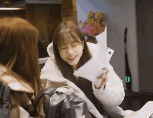 a girl in a white coat is holding a piece of paper