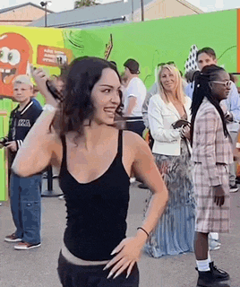 a woman is standing in front of a crowd of people .
