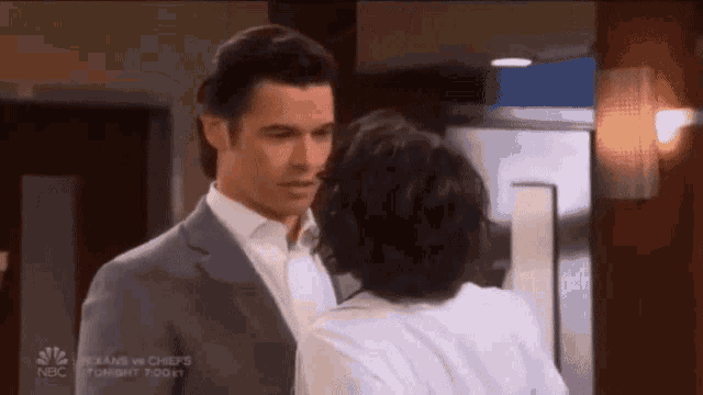 a man in a suit and a woman in a white shirt are standing next to each other ..