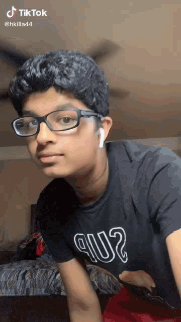 a young man wearing glasses and a t-shirt that says 9002