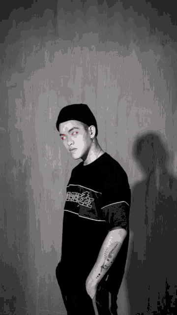a man with red eyes is wearing a black shirt that says ' booze ' on the front