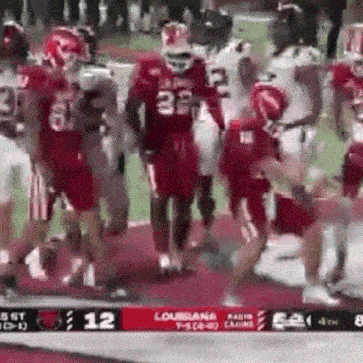 a group of football players are standing on the field .