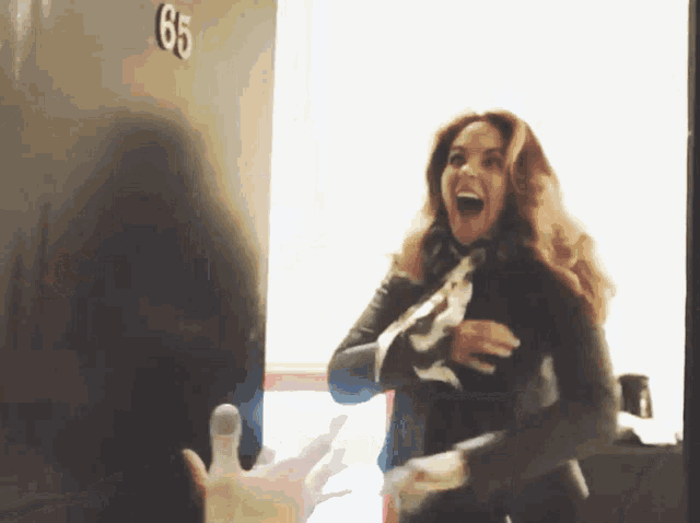 a woman stands in front of a door that says 65