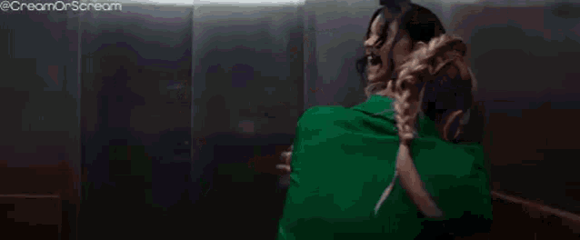 a woman is brushing her hair in a dark room with a brush .