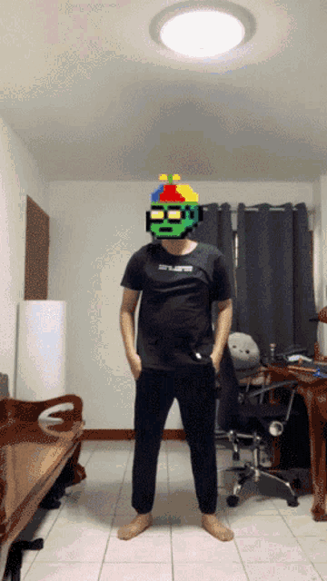 a man wearing a black shirt that says ' stealth ' on it stands in a living room