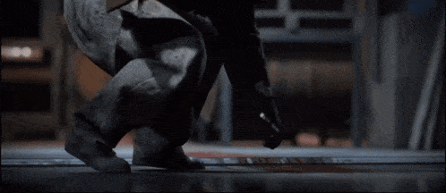 a man is kneeling down in a dark room with a sign that says ' a ' on it