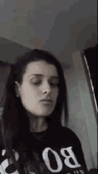 a woman is making a funny face while wearing a black shirt with the number 80 on it .