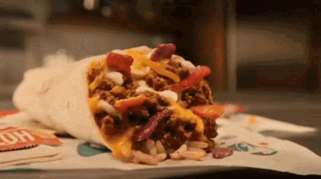 a burrito with a lot of toppings is on a table