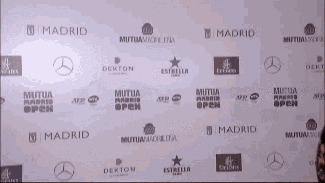 a wall with many logos on it including mutua madrid open