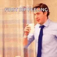 a man in a suit and tie is holding a cup of coffee and saying `` first sip feeling '' .