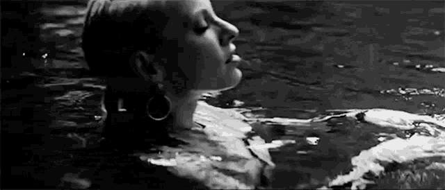 a black and white photo of a woman in the water .