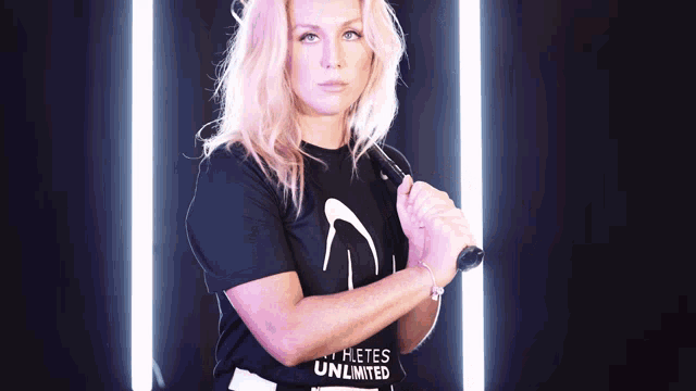 a woman wearing a black shirt that says ' athletes unlimited ' on it