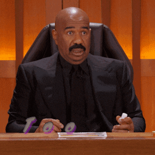 a man in a suit and tie sitting at a desk with the number 10 in his hand