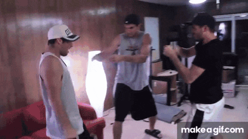 three men are standing in a room and one of them is wearing a hat with the letter d on it ..