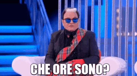 a man wearing sunglasses and a plaid scarf says che ore sono ?