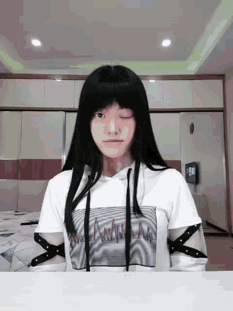 a girl wearing a white hoodie with a wave pattern on the front