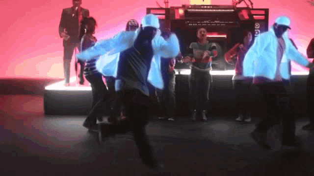 a group of people are dancing in front of a microphone that says ' a ' on it