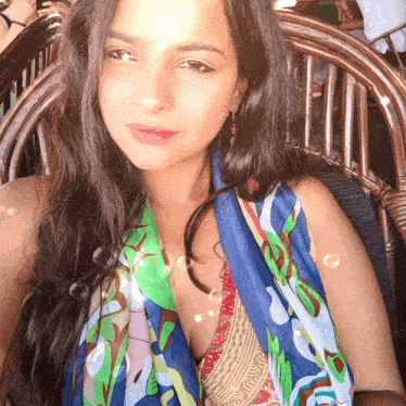 a woman wearing a scarf around her neck sitting in a chair