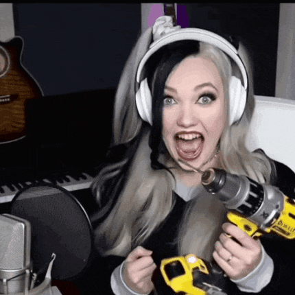 a woman wearing headphones is holding a dewalt drill with her mouth open