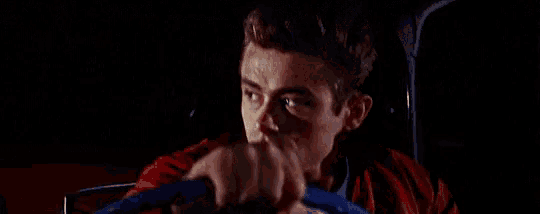 a man in a red jacket is holding the steering wheel