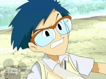 a boy wearing glasses and a disney shirt is standing on a beach .