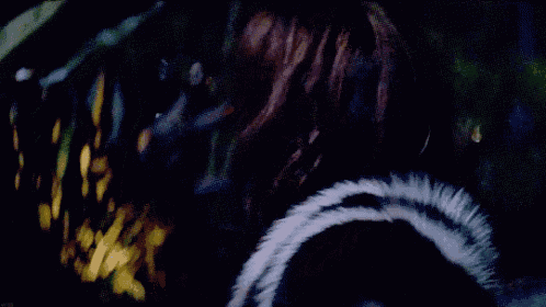 a close up of a woman 's face with black lipstick and a fur coat .