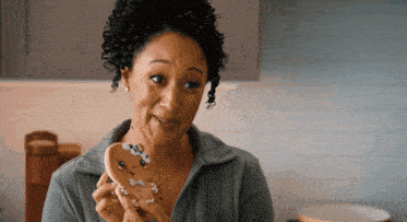 a woman is holding a cookie with a gingerbread man on it