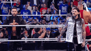 a group of wrestlers are standing in a ring with a crowd behind them and a hashtag that says thekamdreesen