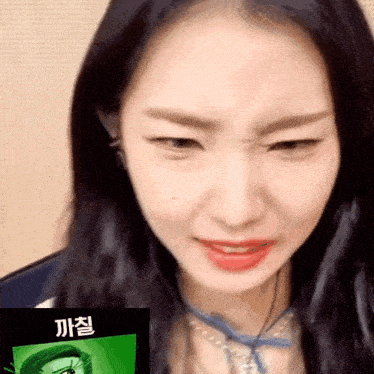 a close up of a woman making a funny face with a green background .