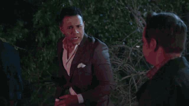 a man in a suit is talking to another man in a suit