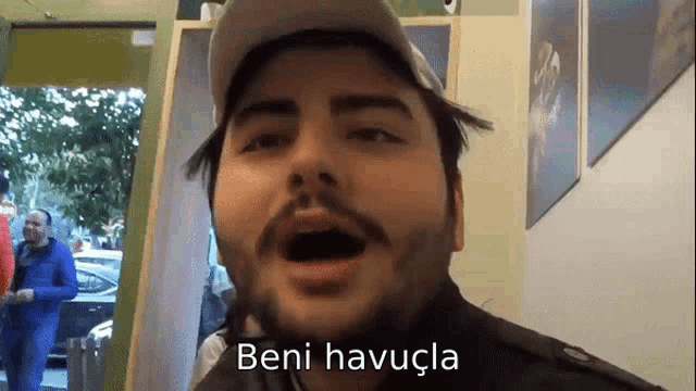 a man with a beard is wearing a hat and says beni havuçla