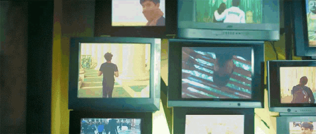 a bunch of televisions are stacked on top of each other including one that says ' jvc ' on it