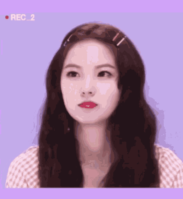 a woman 's face is shown with a purple background and the words rec 2 on the bottom right