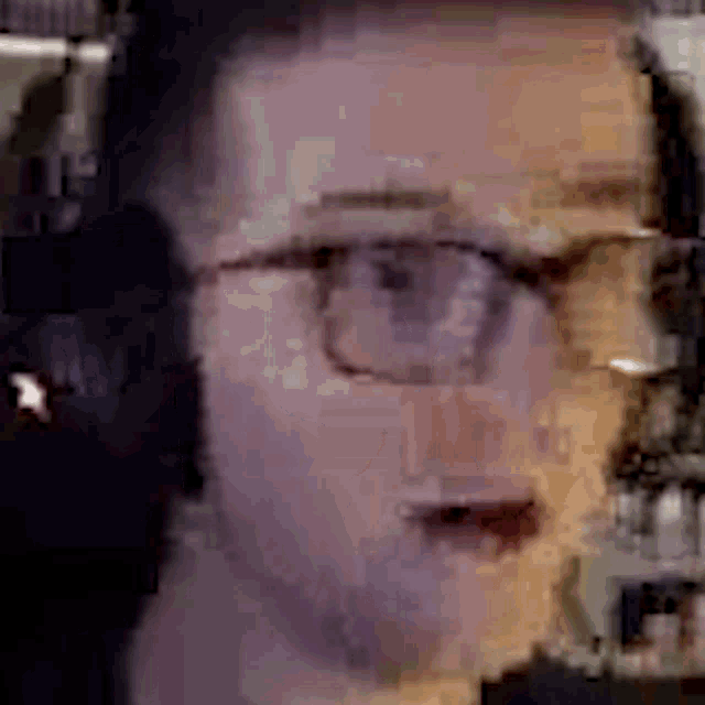 a close up of a man 's face with glasses