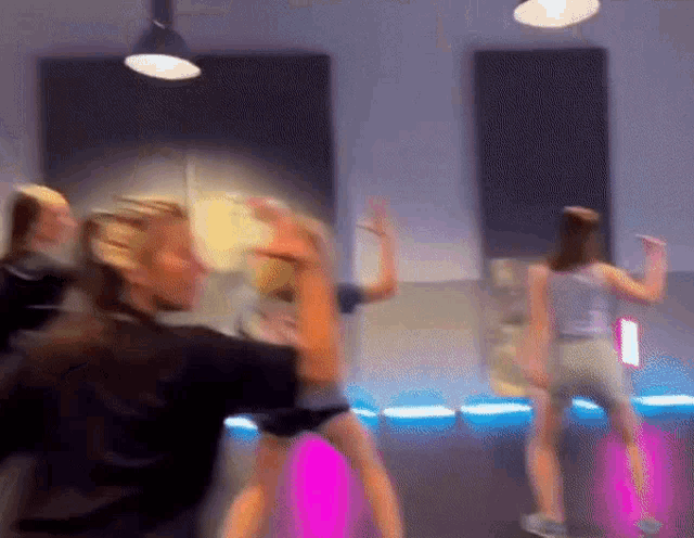 a blurry picture of a group of people dancing in a room