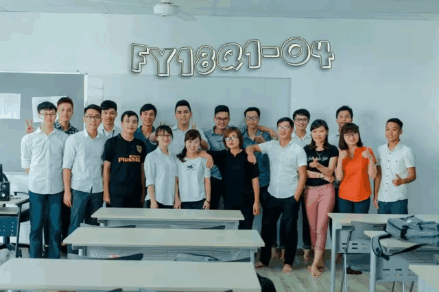 a group of people posing for a picture in front of a sign that says fy18q1-4