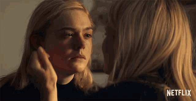 a woman touching another woman 's face with netflix written on the bottom