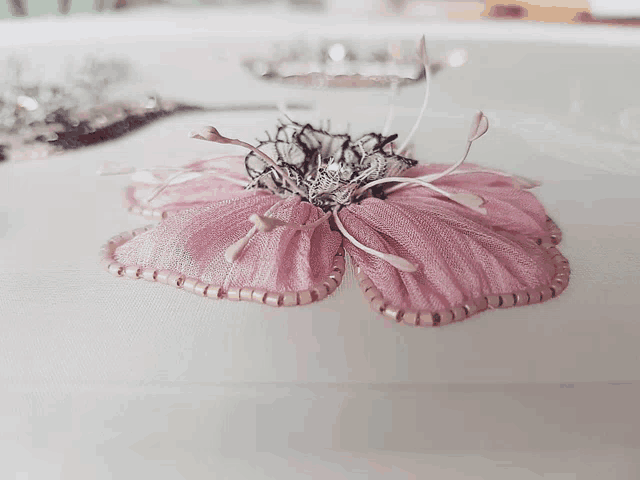 a close up of a pink flower with beads