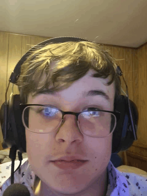a young man wearing glasses and headphones is making a funny face