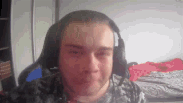 a man wearing headphones looks at the camera and makes a funny face