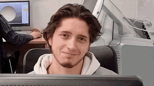 a young man sitting in front of a computer screen