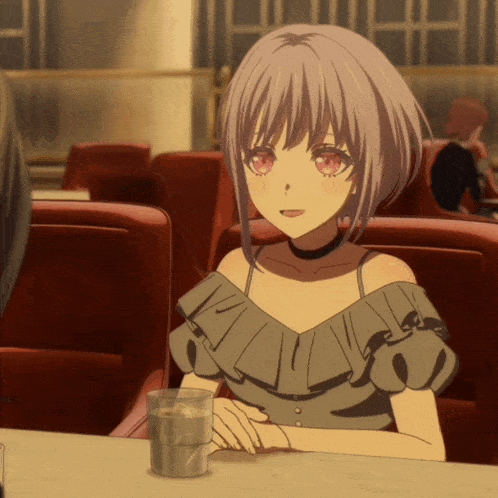 a girl with a choker sits at a table with a glass of water