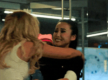 two women are hugging each other and one of them is crying