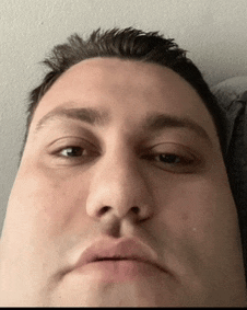 a close up of a man 's face with a slight smile on his face