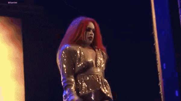 a woman with red hair is dancing on a stage
