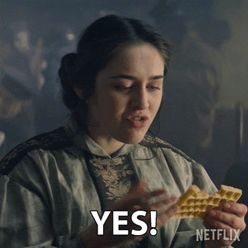 a woman holding a piece of food with the word yes written on it