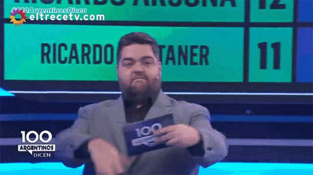a man holding a 100 argentinas dicen card