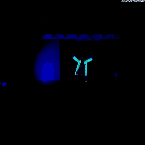 a man in a white coat is standing in the dark behind a sign that says naomi