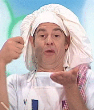 a man is wearing a chef 's hat and apron with the letter v on it