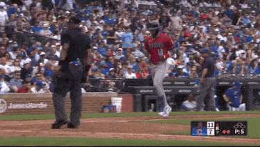a baseball player with the number 12 on his jersey is running towards home plate